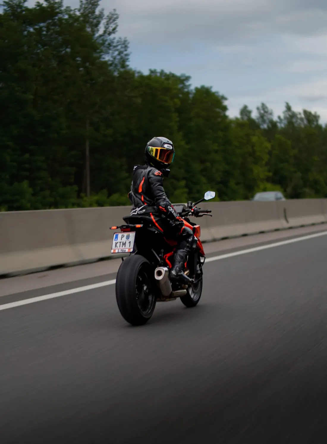 Motorcyclist riding on an alpine road in a custom-fitted leather suit